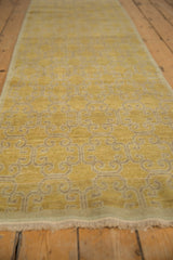 Distressed Khotan runner, showcasing saffron yellow curvilinear panel design and worn pile.