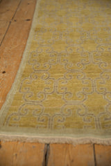 Distressed Khotan runner end, light ivory fringe, worn saffron yellow pile, floral motif.