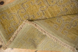 Fringed end and woven foundation of the distressed Khotan runner with textured pile.