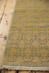 Textured pile of vintage distressed Khotan runner with saffron gold abrashes and panel design.