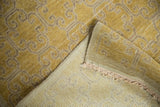 Distressed vintage Khotan rug corner, showing saffron yellow pile, abrashes, and hand-knotted foundation.