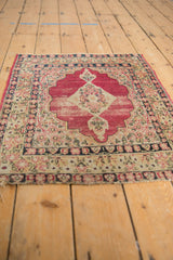 Close-up of antique Kerman rug's unusual geometric medallion, cochineal red field, and intricate millefleur details.