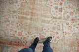 Vintage Oushak carpet detail: ivory, blue, terra cotta floral motifs and visible wear.