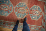 Vintage distressed Caucasian rug with abrashed cinnabar red field and powder blue geometric medallions.