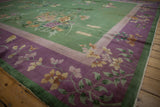 Vintage Art Deco carpet's deep purple border, sprawling ivory floral vines, emerald green edge.