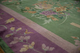 Vintage Chinese Art Deco carpet: mauve border with plants overflowing onto emerald green field.
