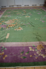 Chinese Art Deco carpet: vased plants, lotus flowers, emerald green field, and mauve border.