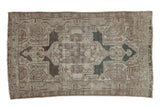 Distressed vintage Hamadan rug, shield medallion with boteh, in faded beige, silver, and pale blue.
