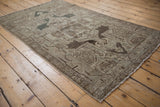 Distressed Hamadan rug corner: geometric border, faded boteh motifs, even wear with subtle blue hues.