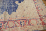 Distressed main border of vintage Oushak carpet, featuring faded blush red palmettes and blue motifs.