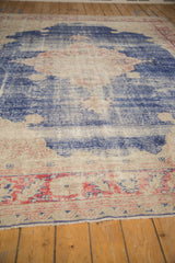 Distressed Oushak rug border, showcasing faded blue, blush, ivory tones and worn texture.