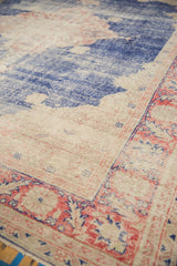 Distressed texture showing pale royal blue abrash, beige field, and faded blush red border.