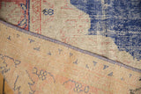 Vintage distressed Oushak rug's blue selvage and visible hand-knotted reverse.