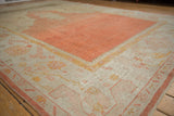 Wide banded border with pale tangerine orange and saffron motifs on vintage Oushak rug.