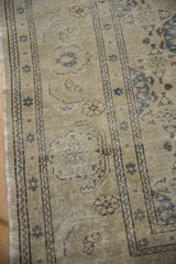Faded roundel border and trellis patterns of a distressed vintage Sivas carpet in beige and blue.