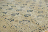 Distressed vintage Sivas carpet showing beige pile, navy motifs, and border detail.