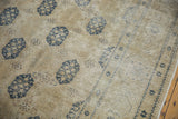 Distressed Sivas carpet detail with beige and dusty navy germinating plants and worn texture.
