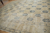 Distressed Sivas rug with worn navy trellis motifs on an ivory and sand field.