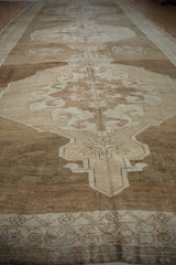 Distressed Oushak rug with curvilinear beige, antique ivory, and pale blush medallion motif.