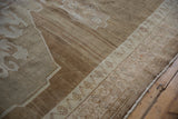Heavily abrashed beige and sand pile of distressed Oushak rug, showing border pattern.