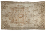 Distressed Oushak carpet, an oversized medallion in soft ivory, beige, and bronze tones.