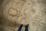 Distressed vintage Oushak carpet showing faded scrolling floral motifs and soft, even wear.