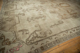 Distressed Oushak rug with mostly even wear, highlighting beige tones and abstract pink motif.