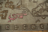 Vintage Distressed Oushak rug detail: beige field, brown scrolling tendrils, vibrant pink, geometric border.