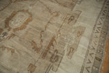 Worn pile texture with visible knot heads and brown geometric border pattern.