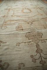 Distressed ivory pile with nuanced pale bronze geometric patterns of a vintage Oushak rug.