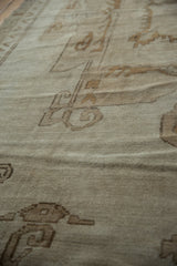 Distressed pile texture of a vintage Oushak carpet showing mostly even wear and soft neutral tones.