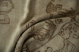 Vintage distressed Oushak carpet close-up, showing worn pile with organic motifs in beige.