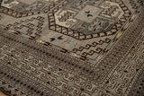 Distressed Ersari carpet corner, showcasing geometric guls, stepped medallions, and oxidized silver, charcoal hues.