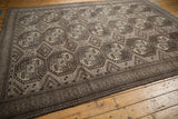 Geometric gul motifs and border on distressed vintage Ersari rug in silver, charcoal, ivory.