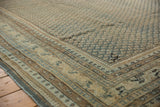 Distressed vintage Mir Sarouk rug border showcasing worn pile and faint foundation in navy, beige.