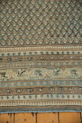 Distressed Sarouk rug detail: patterned striped border, pale blues, beige, and fringe.