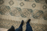 Distressed vintage Ersari carpet, overhead view with feet on pale navy geometric guls.