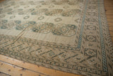 Distressed Ersari carpet corner: geometric motifs in ivory, pale navy, and coffee brown.