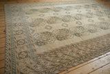 Softened tones on the decorative geometric border of vintage distressed Ersari rug.