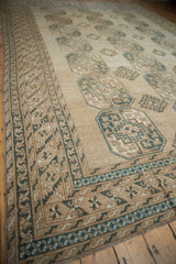 Distressed vintage Ersari carpet: geometric border with pale navy blue and coffee brown gul motifs.