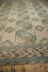 Decorative border with pale dusty navy blue motifs and geometric guls on distressed Ersari rug.