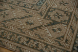 Distressed pile texture revealing geometric floral guls in coffee brown, ivory, dusty blue.