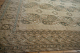Distressed Ersari carpet showcasing geometric guls, patterned borders, in ivory, pale navy, and coffee.