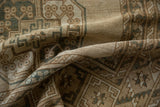 Distressed Ersari carpet pile texture, featuring geometric guls in ivory, brown, and pale dusty navy.