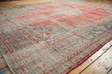 Distressed Oushak rug border showing serrated leaf motif and faded pale red field.