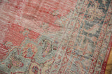 Distressed vintage Oushak rug close-up, worn pale red and oxidized silver tones.