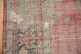 Distressed vintage Oushak rug edge with red selvage, worn pile, and visible foundation.
