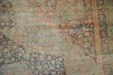 Antique Distressed Kerman carpet with visible worn foundation, faded teal and red floral patterns.