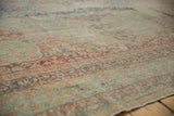 Antique Kerman carpet surface detail, highlighting exposed knot heads and faded millefleur motifs.