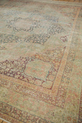 Distressed antique Kerman carpet's detailed millefleur floral pattern in faded red and teal.